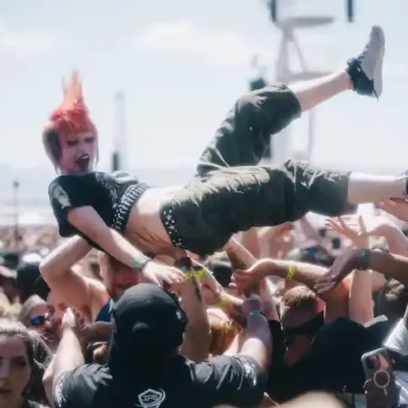 A crowd surfer carried above the audience at Sick New World